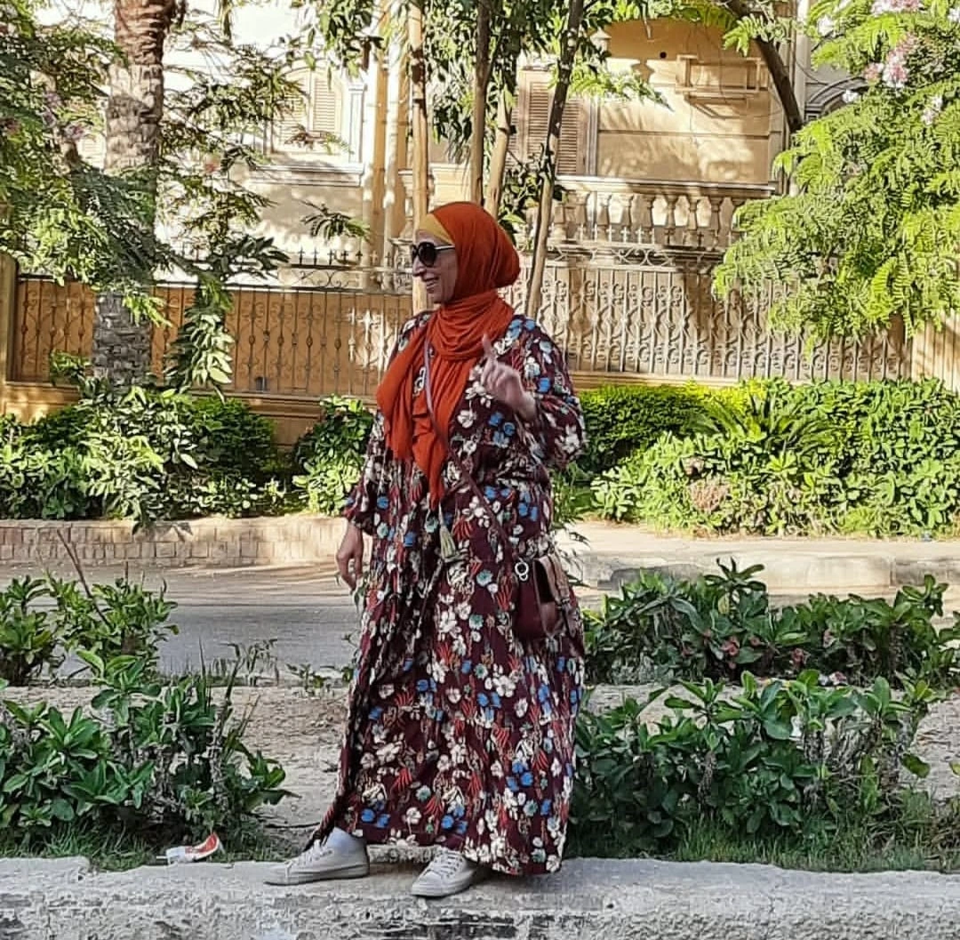 Abeer showcasing one of her homemade dresses in the urban landscape of Cairo.