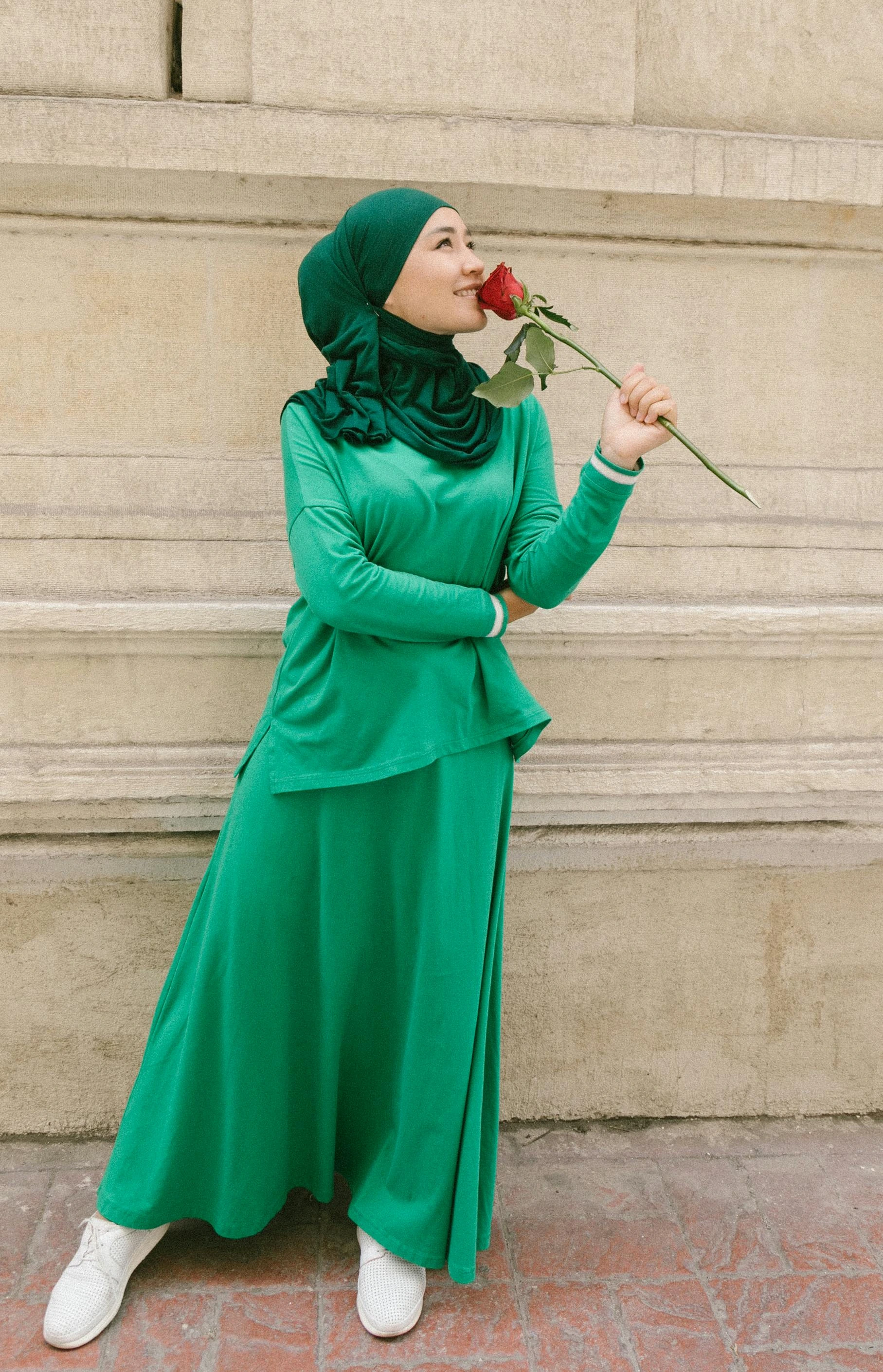 A Muslim woman wearing a bright green skirt