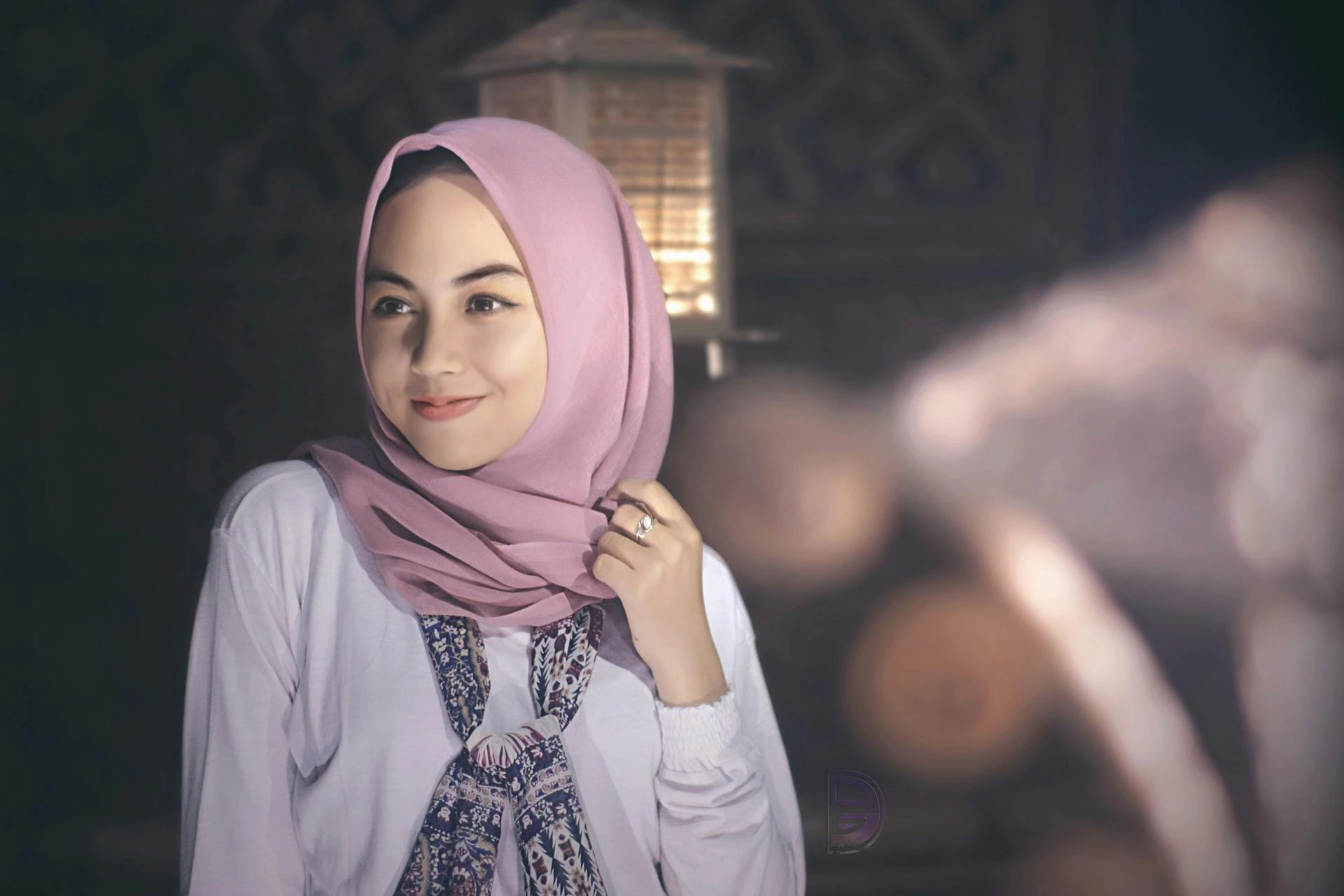 A young Muslim woman wearing a fashionable blouse, who is a client of the seamstress.
