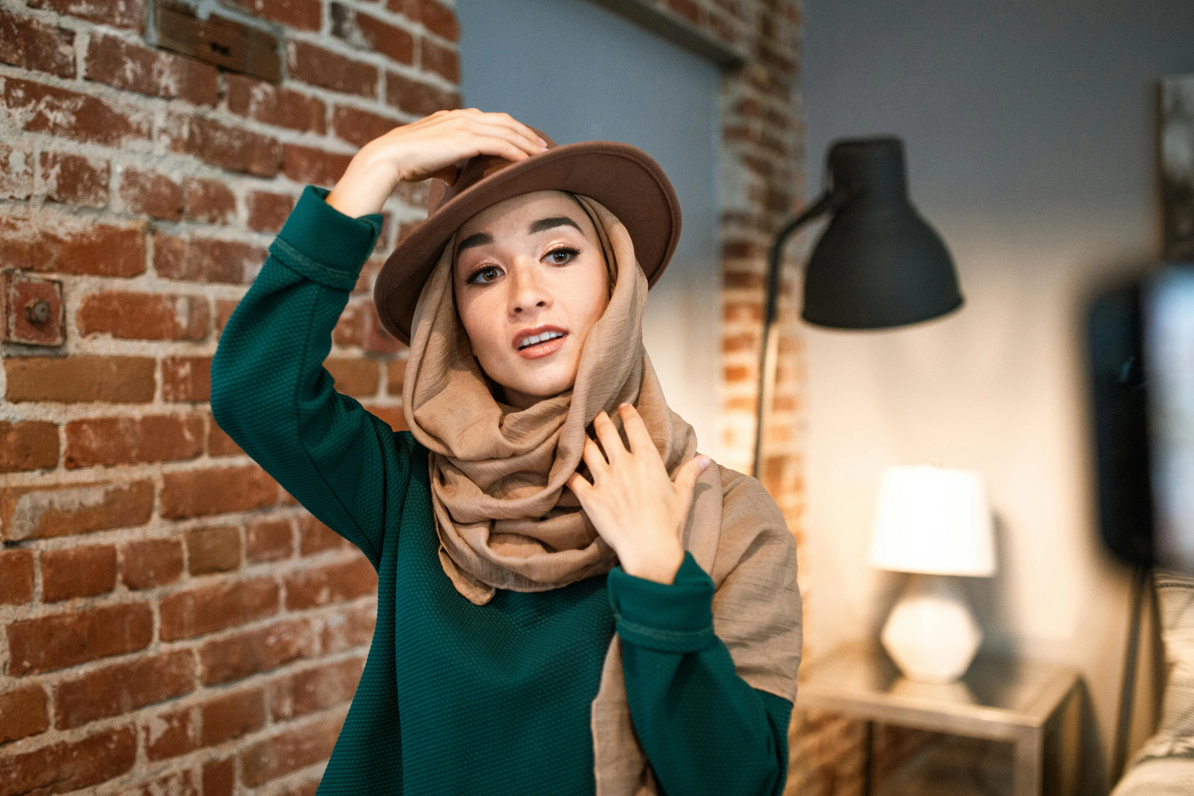 A Muslim woman who experiments with both her headscarf and a strawhat.